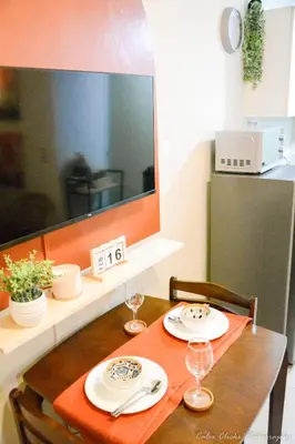 a table with two plates and wine glasses on it at The Soft Stay 1BR SM Jazz Makati in Manila