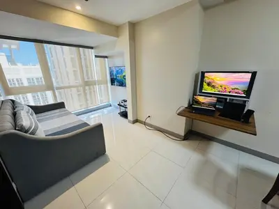 a living room with a couch and a flat screen tv at Functional and Convenient stay in Eastwood City in Manila