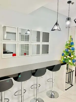 a kitchen with a bar with stools and a christmas tree at penthouse condo in Azure - near airport in Manila