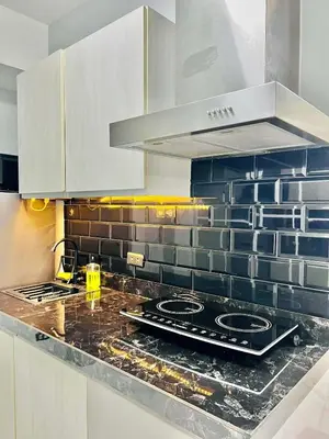 a kitchen with a counter top with a stove at penthouse condo in Azure - near airport in Manila