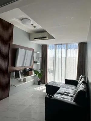 a living room with a couch and a flat screen tv at penthouse condo in Azure - near airport in Manila