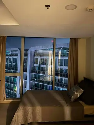 a bedroom with a large window with a view of a city at staycation at azure - near airport in Manila