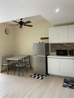 a kitchen with a refrigerator and a table with chairs at staycation at azure - near airport in Manila