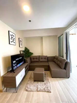 a living room with a couch and a flat screen tv at staycation at azure - near airport in Manila