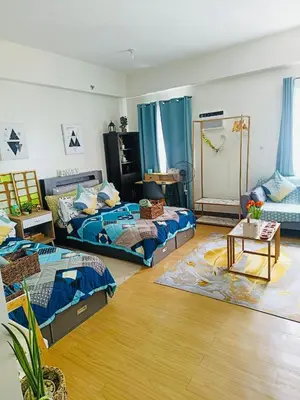 a living room with two beds and a table at Casa Verde Suite - Staycation