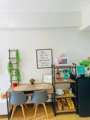 a kitchen with a table and two chairs and a microwave at Casa Verde Suite - Staycation