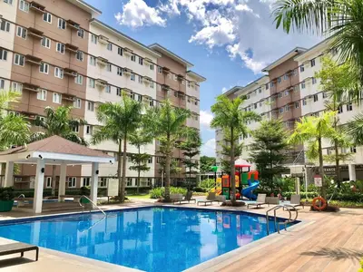 a pool at a hotel with a playground and palm trees at Casa Verde Suite - Staycation
