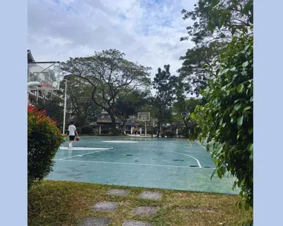 a man is playing basketball on a basketball court at Modern 2BR Condo in Acacia Estate, Quiet & Green in Manila
