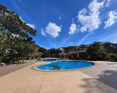 a swimming pool in a park with a blue sky at Modern 2BR Condo in Acacia Estate, Quiet & Green in Manila