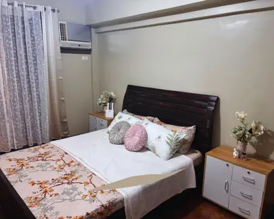 a bedroom with a bed with two pillows on it at Modern 2BR Condo in Acacia Estate, Quiet & Green in Manila