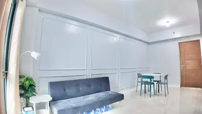 a living room with a blue couch and a table at Spacious Family Room Near NAIA Airport in Manila