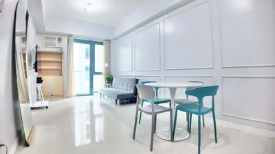 a living room with a table and chairs at Spacious Family Room Near NAIA Airport in Manila