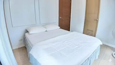 a small bedroom with a white bed in a room at Spacious Family Room Near NAIA Airport in Manila