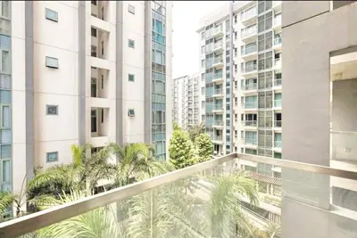 a balcony with palm trees in front of tall buildings at Spacious Family Room Near NAIA Airport in Manila