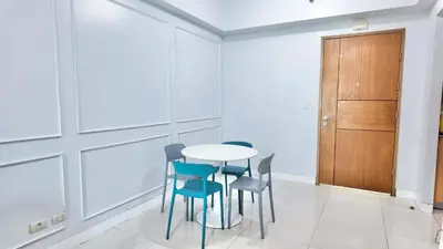 a table and chairs in a room with a door at Spacious Family Room Near NAIA Airport in Manila