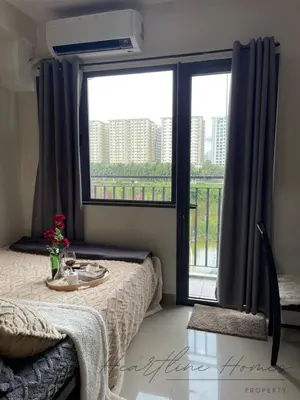 a bedroom with a table and a large window at Heartline Homes Shore 2 Residences in Manila