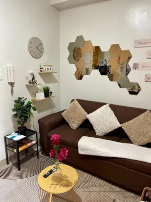 a living room with a brown couch and a table at Heartline Homes Shore 2 Residences in Manila