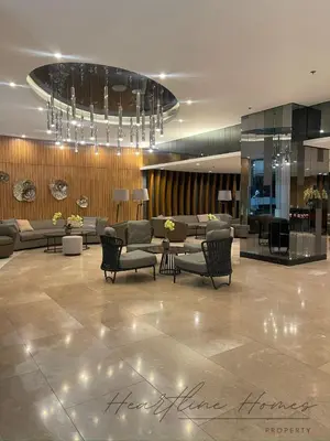 a lobby with couches and chairs and a chandelier at Heartline Homes Shore 2 Residences in Manila