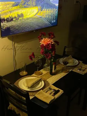 a table with a plate of food and glasses of wine at Heartline Homes Shore 2 Residences in Manila