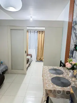 a living room with a table and a room at Luxx Place in Manila