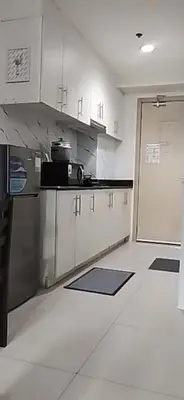 a kitchen with stainless steel cabinets and a refrigerator at Luxx Place in Manila