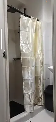 a bathroom with a shower with white towels at Luxx Place in Manila