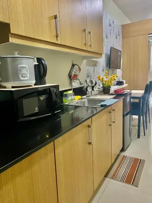 a kitchen with a sink and a microwave at Queen Magzy Place in Manila