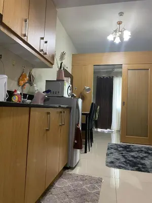 a kitchen with a refrigerator and a microwave at Queen Magzy Place in Manila