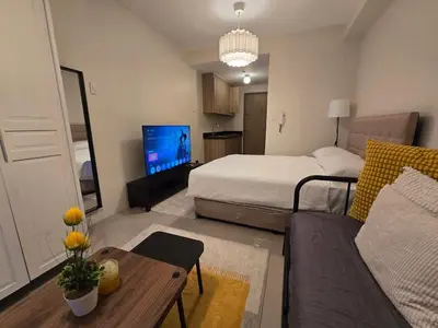 a living room with a bed and a couch at Cozy Modern Studio Near MOA Brand New Furnishings in Manila