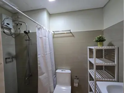 a bathroom with a shower and a toilet and a sink at Cozy Modern Studio Near MOA Brand New Furnishings in Manila