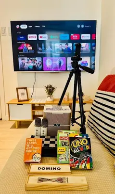 a table with a camera and books and a tv at Deluxe penthouse unit at azure - near airport in Manila