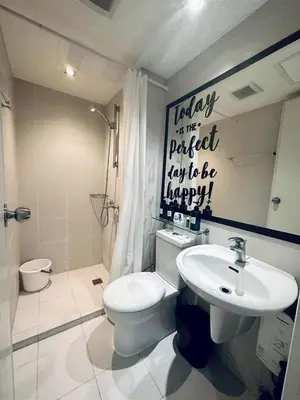 a bathroom with a white toilet and a sink at Deluxe penthouse unit at azure - near airport in Manila