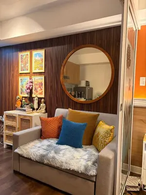 a living room with a couch with colorful pillows at Family room at azure - near airport in Manila