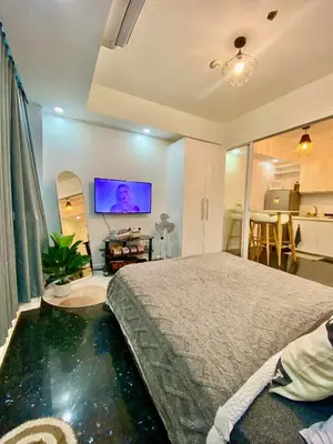 a bedroom with a large bed and a flat screen tv at Family room at azure - near airport in Manila