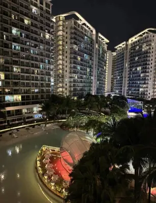 a view of a city at night with tall buildings at Family room at azure - near airport in Manila