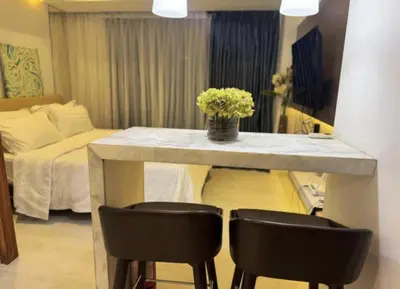 a room with a table with two chairs and a bed at Family room at azure - near airport in Manila
