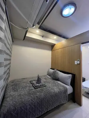 a bedroom with a bed with a cat sitting on it at shell residences -RJ in Manila