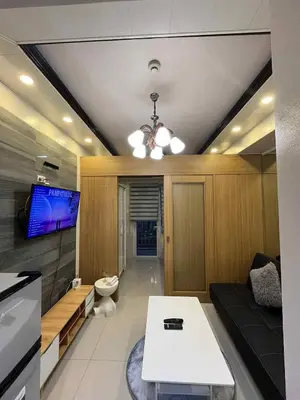 a living room with a couch and a tv at shell residences -RJ in Manila