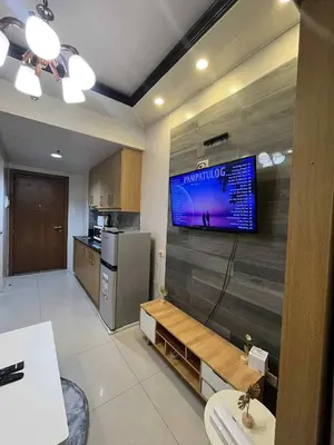 a kitchen with a flat screen tv on a wall at shell residences -RJ in Manila