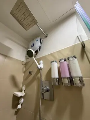 a bathroom with a shower with a blow dryer at Condotel 1BR w balcony at MOA SMDC Shore3 T1 in Manila