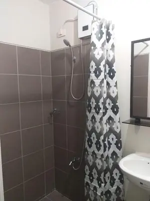 a bathroom with a shower with a black and white shower curtain at MetroStay Studio Legarda in Manila