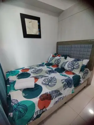 a bedroom with a bed with a colorful comforter at Sea Residences Staycation by Gladys in Manila
