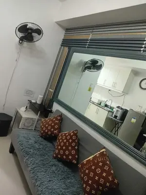 a living room with a couch and a large window at Condotel Sea Residence's Place Near Moa in Manila