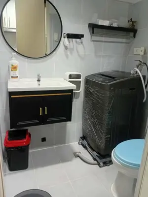 a bathroom with a sink and a toilet and a mirror at Condotel Sea Residence's Place Near Moa in Manila
