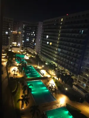 a view of a hotel at night with green lights at Condotel Sea Residence's Place Near Moa in Manila