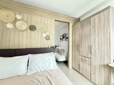 a bedroom with a bed and a large wooden cabinet at Cozy staycation near Mall of Asia in Manila