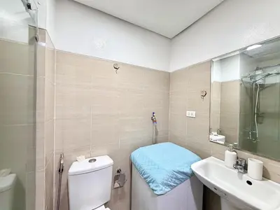 a bathroom with a toilet and a sink and a shower at Cozy staycation near Mall of Asia in Manila