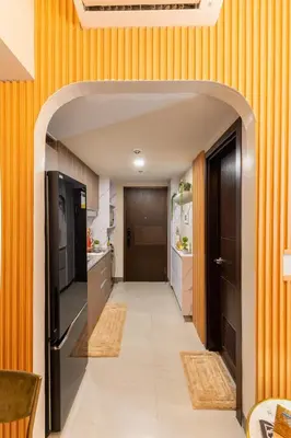 an open hallway with orange walls and a kitchen at Cozy Modern Organic 1BR with Washer and WiFi Near BGC in Manila