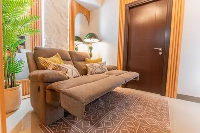 a living room with a couch and a door at Cozy Modern Organic 1BR with Washer and WiFi Near BGC in Manila