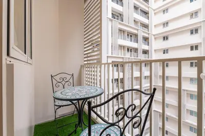 a balcony with a table and chairs and some buildings at Cozy Modern Organic 1BR with Washer and WiFi Near BGC in Manila